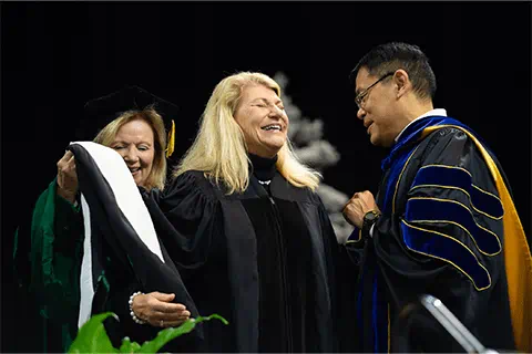 Graduate getting hooded during commencement ceremony